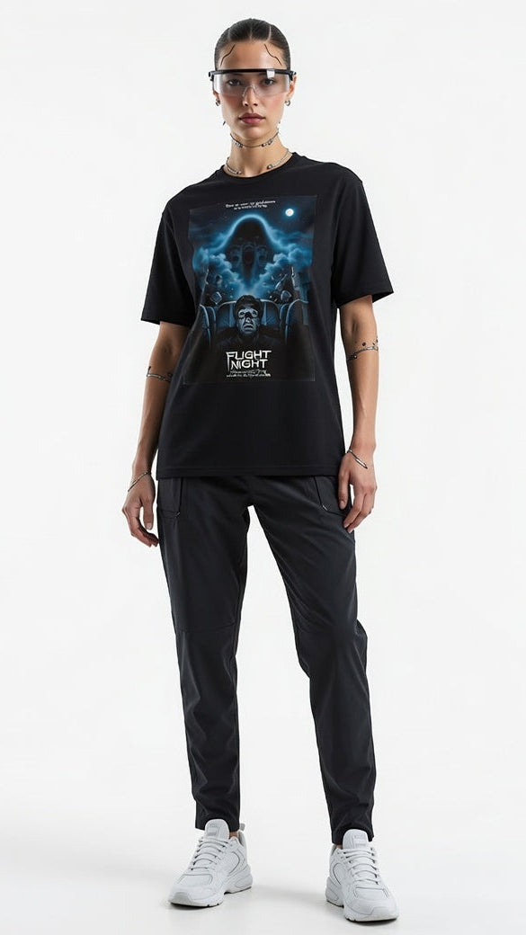 Person wearing a black t-shirt with a graphic design and text, standing against a white background