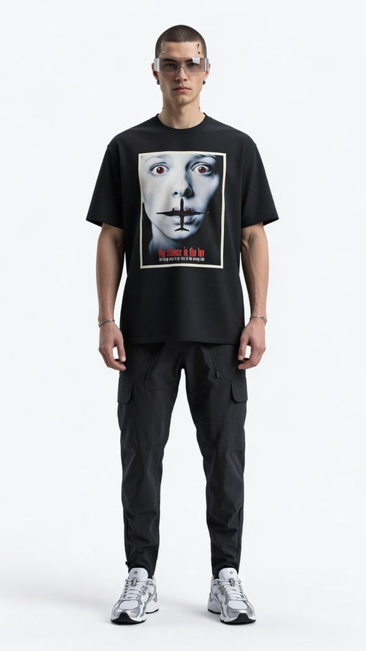 Person wearing a black t-shirt with a graphic design on a white background